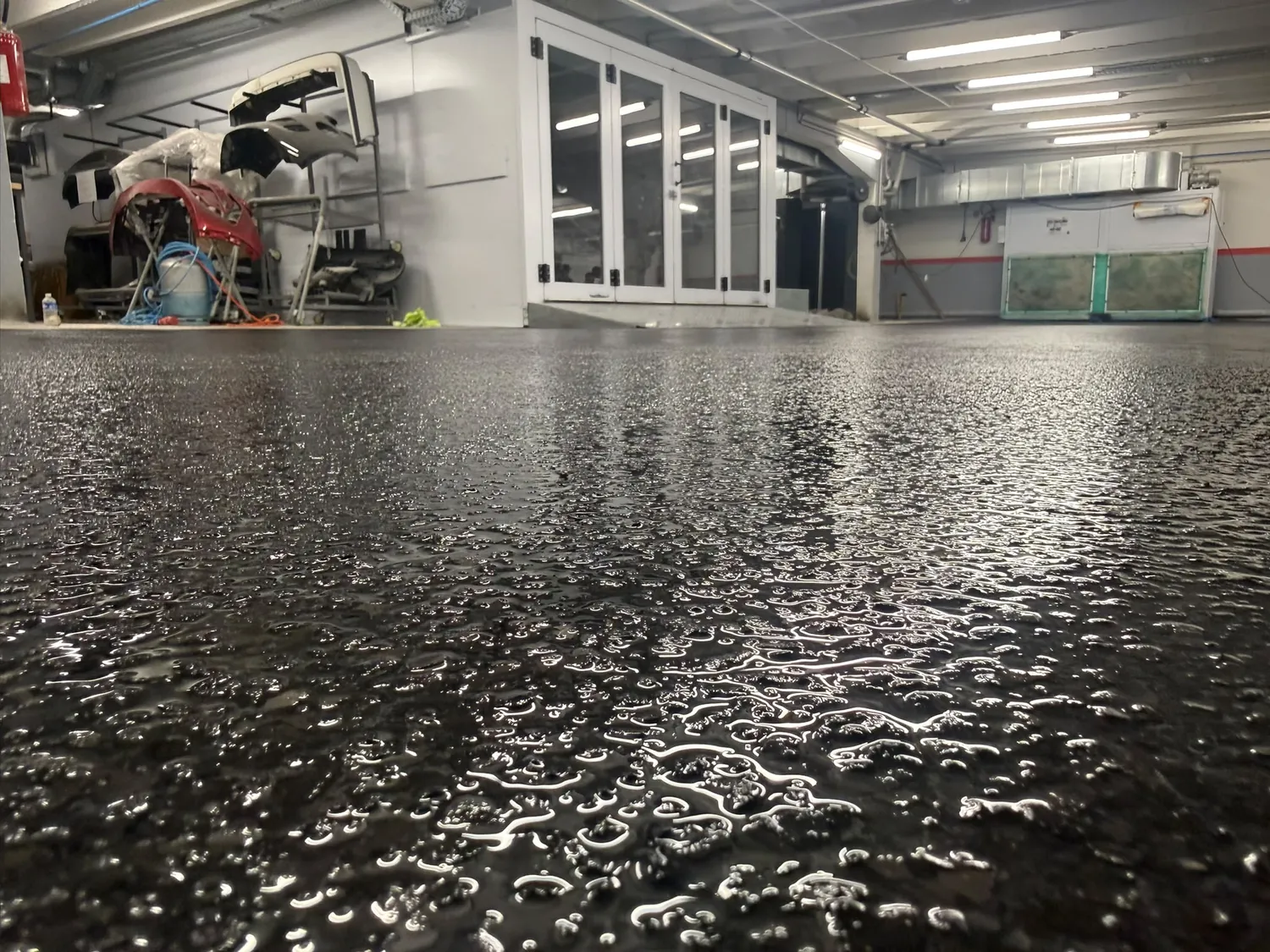 Sol à flocons de vinyle noirs et gris dans un atelier